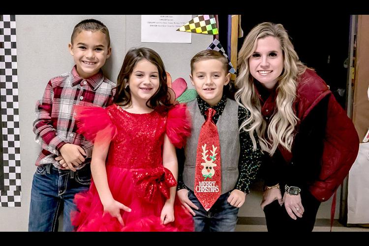 Mrs. Bowker was happy to get a picture with such sharply-dressed kids at the Emerson Elementary Christmas party. She is pictured above with Asher Blue, Whitley Caraway, and Rhett Battles.