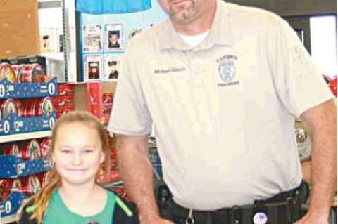 Coalgate police officer Michael Glasco with his Shop with a Cop partner, Libbie Sailer.