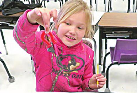 Kaylee Fireshaker happily discovers an item that will stick to her magnet.