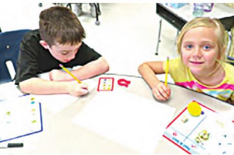 Case Trevathan and Madeline Cagle using magnets to predict and classify objects in their magnet center.