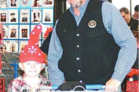 SHOP WITH A COP—Undersheriff Philip Magby was Eddie Harris’s Shop with a Cop partner. See additional photos and story on page B-2.