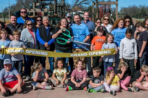 PARK PLAYGROUND RIBBON CUTTING — Directly behind the ribbon are Betty Keilty, Chairman, Coal County Chamber of Commerce; James Frazier, District 12 Councilman, Choctaw Nation of Oklahoma; Tara Sandmann holding the scissors; and Johnny Sandmann. (Photo by Sherry Loudermilk)
